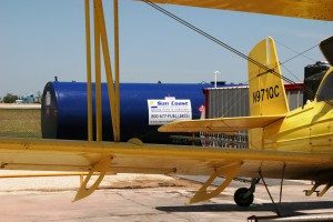 a yellow jet fuel plane and blue fuel tank